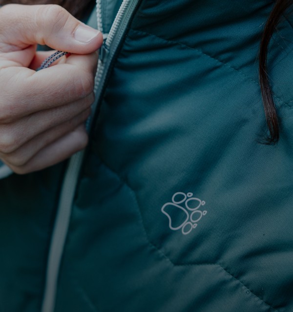 Gros plan d'une main sur la fermeture éclair d'une veste