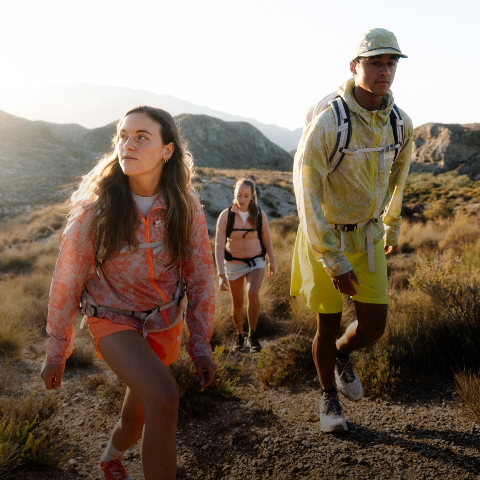 Drie wandelaars in zomerse functionele kleding wandelen op een berg