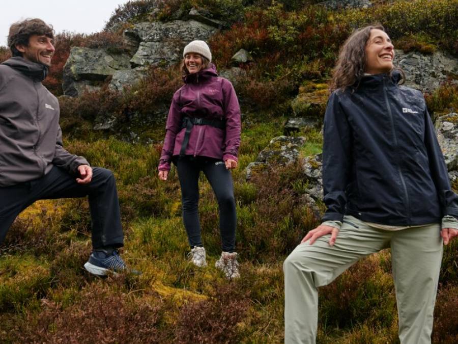 Trois amis dans un site montagneux en train de sourire et de contempler le paysage