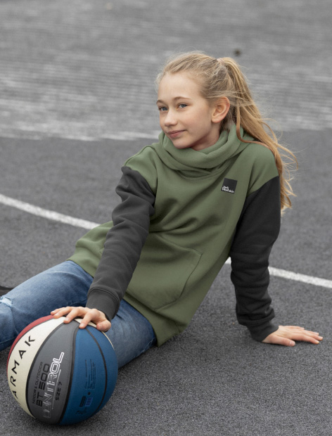 Jeune fille assise sur le sol avec un ballon de basket