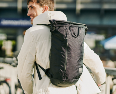 Homme avec sac à dos à fermeture enroulée