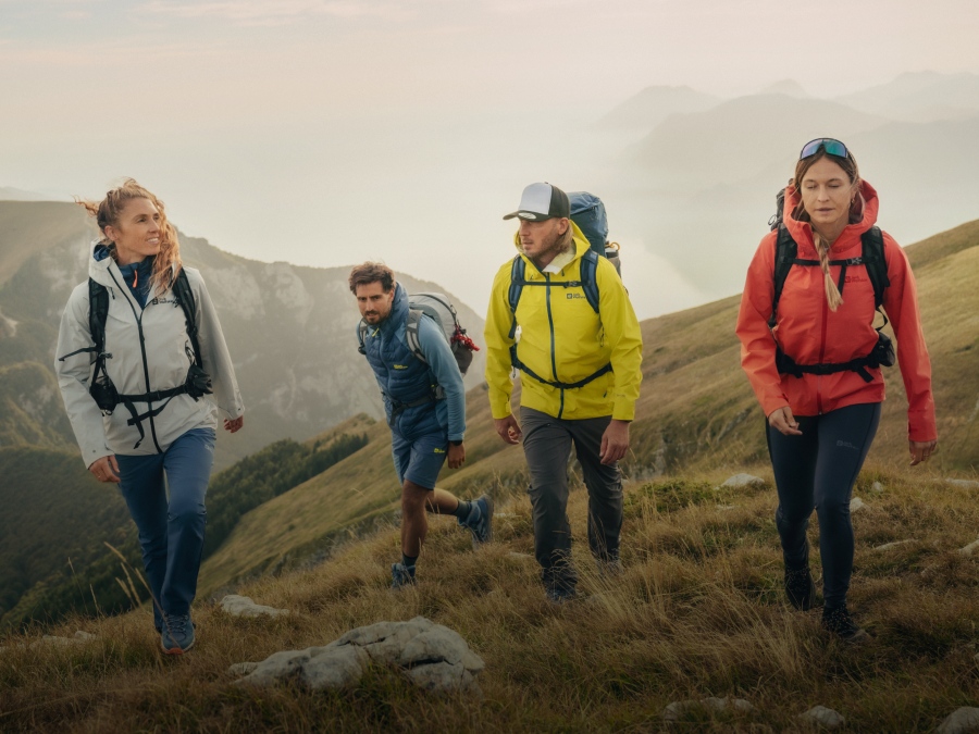 Quatre randonneurs dans un paysage de montagne brumeux