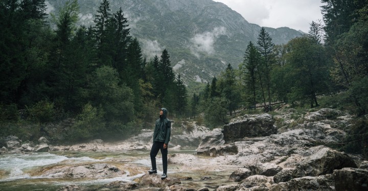 Man in outdoorkleding staat in nevelig berglandschap