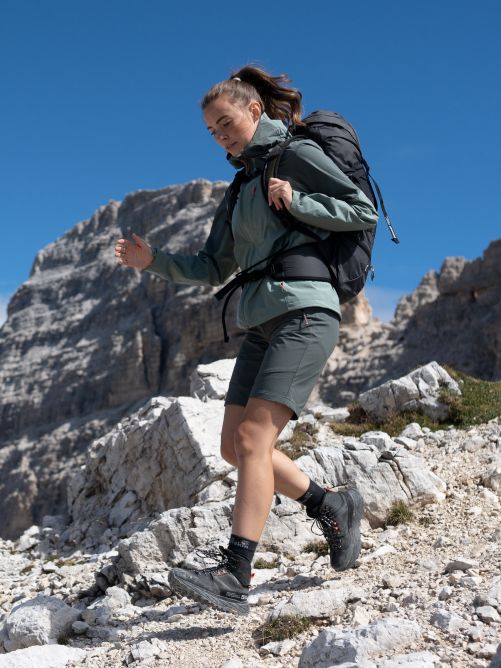 Wandelaar met grote rugzak die bergafwaarts loopt