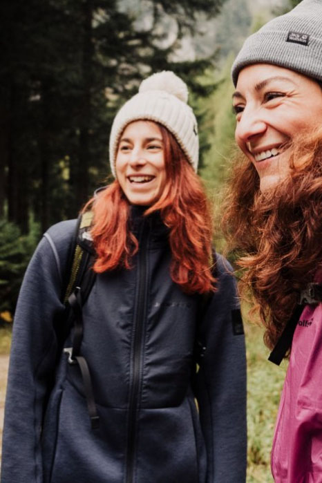 Twee vrolijk lachende vrouwen in de natuur.