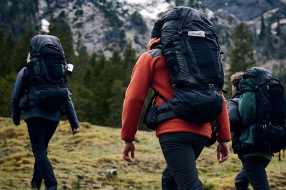 Vue arrière de trois randonneurs avec des sacs à dos de trekking