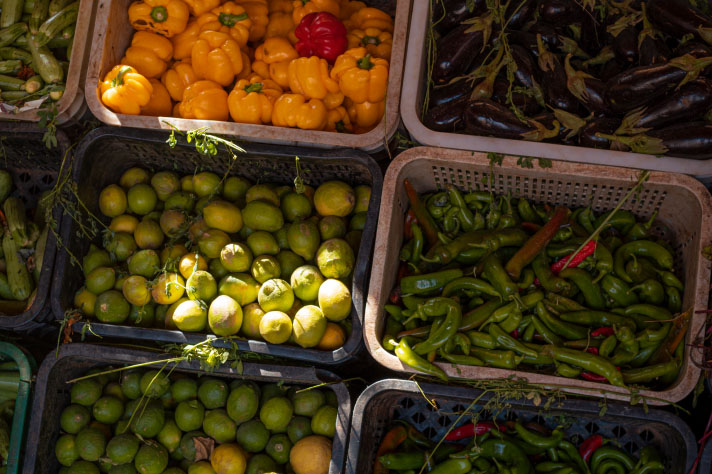 Paprika’s, komkommers, limoenen en aubergines in grote kratten