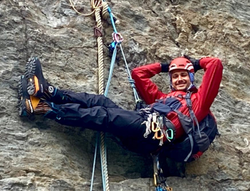 Michel hangend aan een rotswand tijdens het klimmen