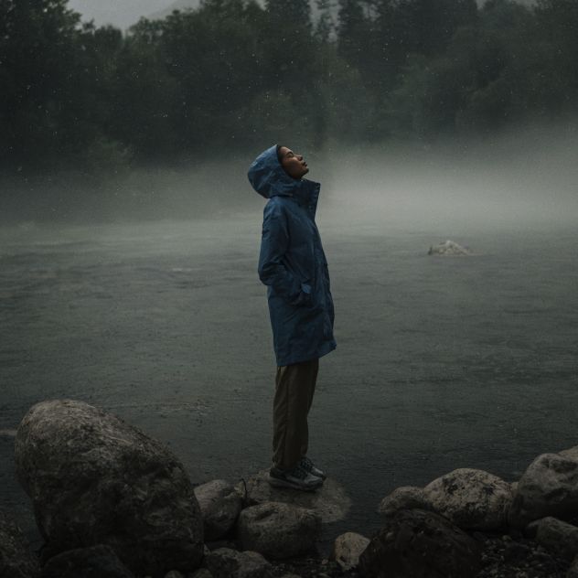 Vrouw staat in de regen